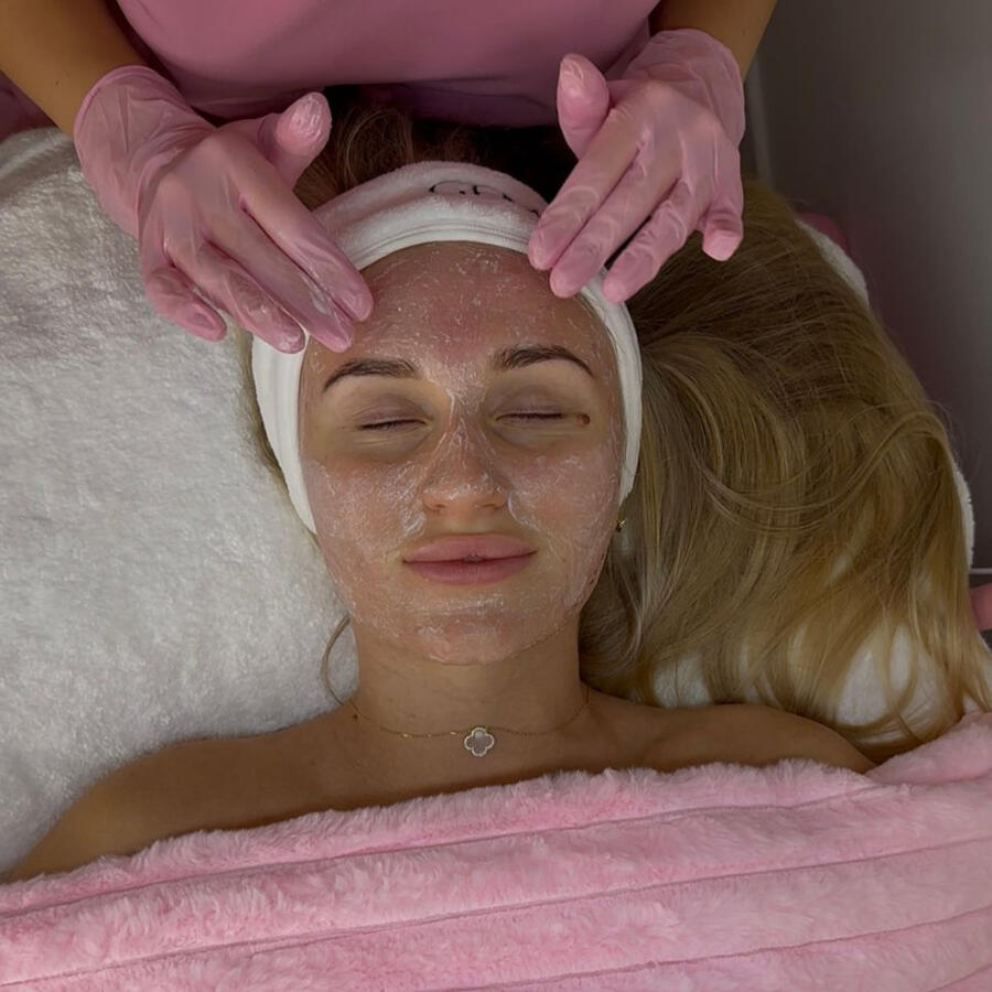 Serene treatment space with cozy pink blanket and skincare cart