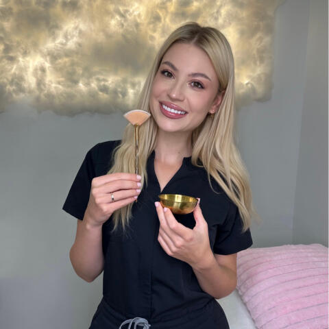 Karina, Licensed Esthetician at Karina Skin Studio holding a mask brush